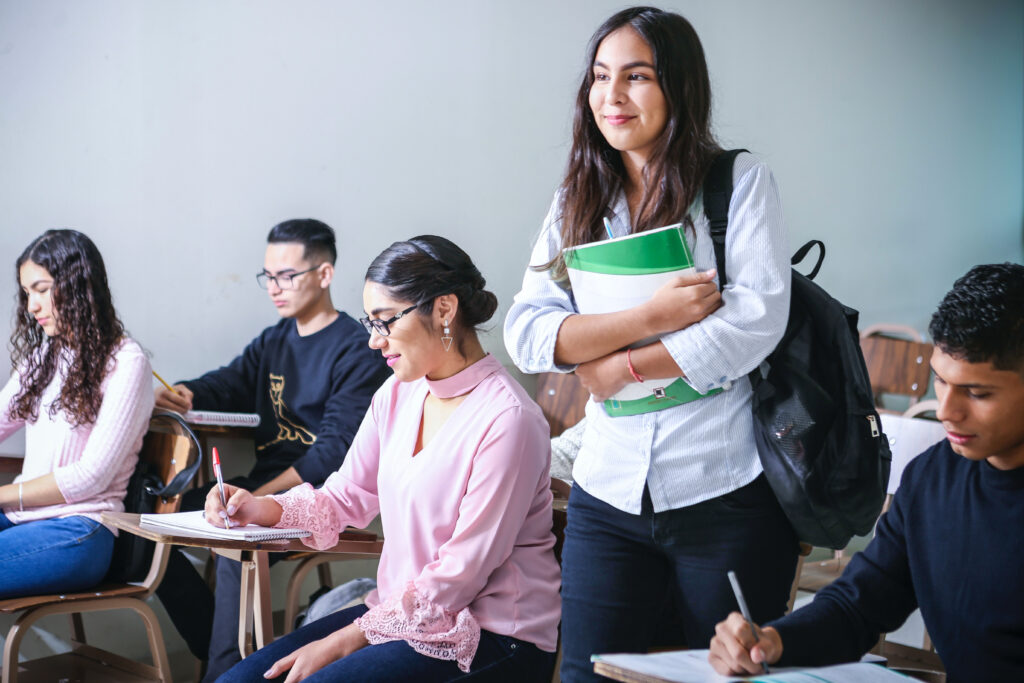 a girl holding a book with people sitting nearby