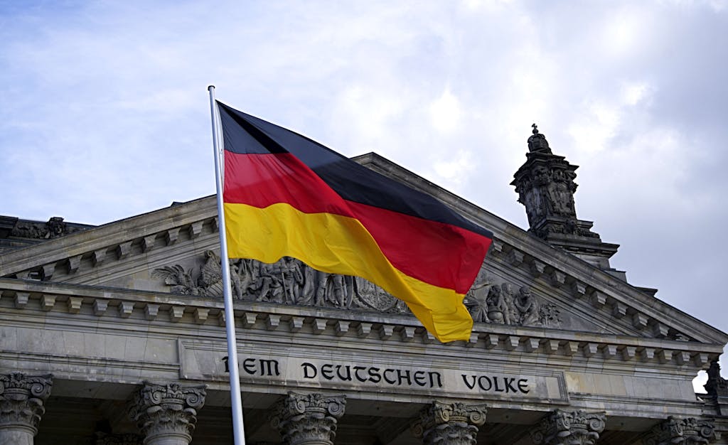 German national flag waving in front of the Reichstag building in Berlin