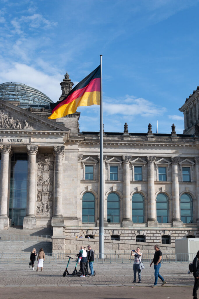 a german flag waving in front of a building